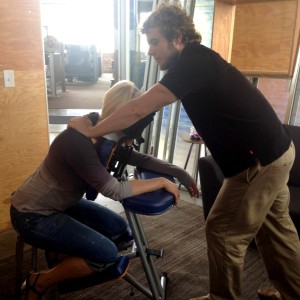 Justin providing chair massage to raise funds for CCFA at Two Rivers Marketing