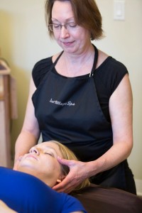 Teresa, a massage therapist at East Village Spa, provides a craniosacral massage to Kelly.